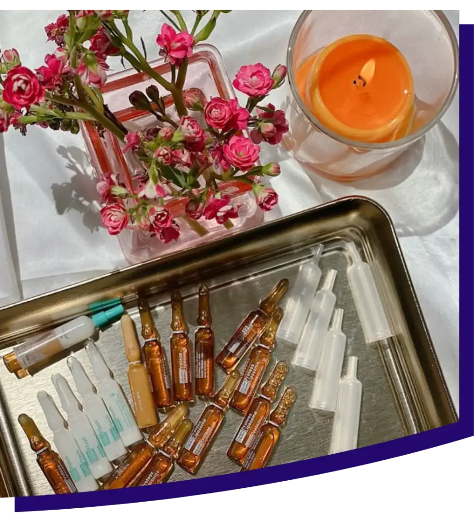 Flat lay of candle, flowers and ampoules on silver tray