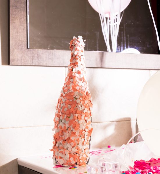 champagne-bottle-covered-with-orange-white-confetti-desk