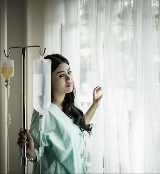 young-woman-looking-through-window-while-standing-by-iv-drip-hospital_1048944-1078011